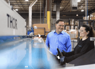 Team members collaborating and smiling as they are reviewing equipment operation. {{brizy_dc_image_alt imageSrc=